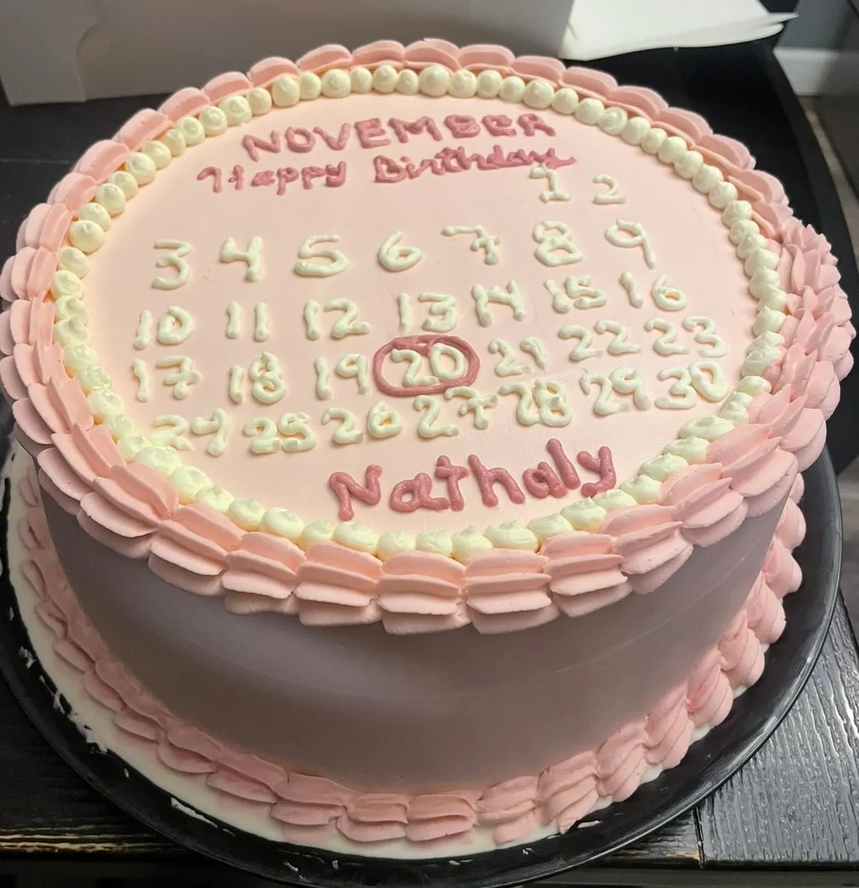 Pink cake piped as a calendar counting down the days, with a circled date
